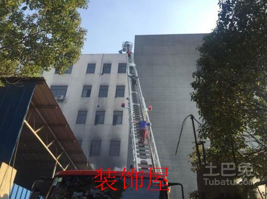 浙江一沙发厂发生大火 现场有人被困楼顶 图为:消防官兵利用登高车疏散被困人员。视频截图